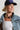 A woman wearing a statement necklace made of natural stones in gold, brown, and blue-gray, paired with a white ribbed tank top and a navy baseball cap-Vintage_Agate_Gold_Statement_Necklace-FleaStyle