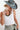 A woman wearing a white ribbed tank top, a dusty blue wide-brim hat, and a vintage necklace that mixes natural wood tones with glossy black beads and stacked disc details for a bold, collected look-Vintage_Black_Natural_Wood_Beaded_Necklace-FleaStyle