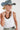 A woman wearing a white ribbed tank top, a dusty blue wide-brim hat, and a vintage necklace that mixes natural wood tones with glossy black beads and stacked disc details for a bold, collected look-Vintage_Black_Natural_Wood_Beaded_Necklace-FleaStyle
