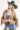 Woman wearing a beige fringe jacket, western buckle strapless top, and pleated patterned skirt with a blue cowboy hat-FleaStyle
