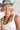 A woman wearing a white ribbed tank top, a dusty blue wide-brim hat, and a vintage necklace that mixes natural wood tones with glossy black beads and stacked disc details for a bold, collected look-Vintage_Black_Natural_Wood_Beaded_Necklace-FleaStyle