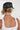 A woman shown from behind wearing a navy blue mesh-back trucker hat and a white ribbed tank top, with a beaded necklace visible-Butterfly-Patch-Trucker-Hat-Navy-FleaStyle.