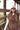 Woman wearing a brown cozy vest and Small-Town-Smokeshow-TruckerHat-Blush_Olive-FleaStyle.