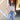 A woman stands outdoors in front of a yellow barn wall, wearing a rust-colored flat-brim hat, a sheer blush flowy pleatd blouse, and floral embroidered blue jeans -Floral Embroidered High Waist Flare Jeans-FleaStyle