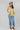 A woman wearing a  lace-trimmed camisole top, paired with medium wash blue jeans with a relaxed wide-leg silhouette and a flattering high waist, brown boots, and a stone cowboy hat, offers the perfect blend of comfort-Medium_Wash_Cuffed_Wide_Leg_Jeans-FleaStyle