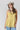 A woman wearing a  gold lace-trimmed flowy camisole top with feminine sholder ties paired with medium wash blue jeans with a relaxed wide-leg silhouette, brown boots, and a stone cowboy hat, offers the perfect blend of comfort-Medium_Wash_Cuffed_Wide_Leg_Jeans-FleaStyle