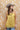 A woman wearing a  gold lace-trimmed flowy camisole top with feminine sholder ties paired with medium wash blue jeans with a relaxed wide-leg silhouette, brown boots, and a stone cowboy hat, offers the perfect blend of comfort-Medium_Wash_Cuffed_Wide_Leg_Jeans-FleaStyle