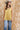 A woman wearing a  gold lace-trimmed flowy camisole top with feminine sholder ties paired with medium wash blue jeans with a relaxed wide-leg silhouette, brown boots, and a stone cowboy hat, offers the perfect blend of comfort-Medium_Wash_Cuffed_Wide_Leg_Jeans-FleaStyle