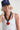 A woman wearing a navy blue trucker-style cap with a colorful butterfly patch on the front, and a chunky black sculptural link necklace finished with an oversized red heart pendant -Vintage_Resin_Heart_Link_Necklace-FleaStyle