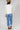 A woman shown from the back wearing a white top with sheer lace sleeves, paired with medium wash blue jeans with a relaxed wide-leg silhouette and a flattering high waist,  brown boots and cowboy hat, offers the perfect blend of comfort--Medium_Wash_Cuffed_Wide_Leg_Jeans-FleaStyle