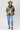 A woman wearing a western-style jacket with camouflage and olive green panels, white embroidered patches, a white graphic tee,  paired with medium wash blue jeans with a relaxed wide-leg silhouette and a flattering high waist,  brown boots and cowboy hat, offers the perfect blend of comfort--Medium_Wash_Cuffed_Wide_Leg_Jeans-FleaStyle