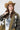 A woman wearing a western-style camo quilted jacket with white embroidered paisley patches, a graphic tee,  relaxed wide-leg silhouetted jean,  brown boots and camel cowboy hat, offers the perfect blend of stylized comfort-Camo_Quilted_Jacket_with_Paisley_Patches-FleaStyle