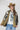 A woman wearing a western-style camo quilted jacket with white embroidered paisley patches, a graphic tee,  relaxed wide-leg silhouetted jean,  brown boots and camel cowboy hat, offers the perfect blend of stylized comfort-Camo_Quilted_Jacket_with_Paisley_Patches-FleaStyle