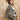 A woman wearing a western-style camo quilted jacket with white embroidered paisley patches, a graphic tee,  relaxed wide-leg silhouetted jean,  brown boots and camel cowboy hat, offers the perfect blend of stylized comfort-Camo_Quilted_Jacket_with_Paisley_Patches-FleaStyle