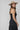 A woman wearing a black tiered strapless midi dress with a smocked bodice, paired with a beige flat-brim hat, turquoise necklace, and brown cowboy boots for a everyday casual elegance --Strapless_Mixed_Media_Midi_Dress_-_Black-FleaStyle