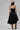 A woman wearing a black tiered strapless midi dress with a smocked bodice, paired with a beige flat-brim hat, turquoise necklace, and brown cowboy boots for a everyday casual elegance --Strapless_Mixed_Media_Midi_Dress_-_Black-FleaStyle