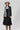 A woman wearing a beige flat-brim hat, a gray pinstripe colorbok asymmetrical plaid blazer over a black strapless tiered midi dress, a turquoise statement necklace and brown cowboy boots offers a structured but relaxed  look--Color_Block_Contrast_Blazer-FleaStyle
