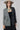 A woman wearing a beige flat-brim hat, a gray pinstripe colorbok asymmetrical plaid blazer over a black strapless tiered midi dress, a turquoise statement necklace and brown cowboy boots offers a structured but relaxed  look--Color_Block_Contrast_Blazer-FleaStyle