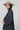 A woman wearing a beige flat-brim hat, a gray pinstripe colorbok asymmetrical plaid blazer over a black strapless tiered midi dress, a turquoise statement necklace and brown cowboy boots offers a structured but relaxed  look--Color_Block_Contrast_Blazer-FleaStyle