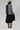 A woman wearing a beige flat-brim hat, a gray pinstripe colorbok asymmetrical plaid blazer over a black strapless tiered midi dress, a turquoise statement necklace and brown cowboy boots offers a structured but relaxed  look--Color_Block_Contrast_Blazer-FleaStyle