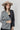 A woman wearing a beige flat-brim hat, a gray pinstripe colorbok asymmetrical plaid blazer over a black strapless tiered midi dress, a turquoise statement necklace and brown cowboy boots offers a structured but relaxed  look--Color_Block_Contrast_Blazer-FleaStyle