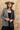 A woman wearing a beige flat-brim hat, a gray pinstripe colorbok asymmetrical plaid blazer over a black strapless tiered midi dress, a turquoise statement necklace and brown cowboy boots offers a structured but relaxed  look--Color_Block_Contrast_Blazer-FleaStyle