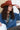 A woman wearing a distressed blue cropped denim jacket with raw frayed edges, a rust curled brim cowboy hat that's warm and spicy, and a brown studded skirt,  outdoors against a light-colored wooden barn-Rider Wool Cowboy Hat - Rust-FleaStyle