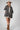A woman wearing a beige and black leopard-print oversized denim jacket paired with a cream-colored shift dress, a beige flat brim hat, dark beaded necklace  and cowboy boots for a fun on the go look-Oversized_Leopard_Denim_Jacket-FleaStyle