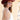 A woman wearing a maroon curl-brimmed cowboy hat and an ivory halter dress, posing in front of a light beige wooden barn wall-Rider_Wool_Cowboy_Hat_-_Maroon-FleaStyle.