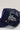 A navy blue trucker cap with a mesh back, featuring a blue and red embroidered patch decorated with two butterfly-shaped stick pins--Vintage_Butterfly_Stick_Pin_-_Blue-FleaStyle