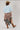 A woman wearing a light blue cropped knit sweater and a brown plaid high-low skirt with frayed edges, wearing a tan cowboy hat --Plaid_Asymmetrical_Tiered_Midi_Skirt-FleaStyle