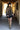 A woman wearing a black cowboy hat, an ornate long beaded black and gold fringe caplet over a black lace tunic standing in a rustic barn-Beaded_Fringe_Capelet_-_Gold-FleaStyle