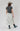A woman modeling a western-style outfit featuring a dark gray graphic t-shirt with 'She's From Texas' in red and white and a toile midi skirt in a classic black and ivory floral print, flattering fitted waist and full pleated silhouette-Floral_Toile_Pleated_Midi_Skirt-FleaStyle