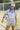 Woman holding a soccer ball with a blue bandana and white cap wearing a Striped-Front-Pocket-Drawstring-Shorts-DustyBlue-Fleastyle
