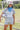 Woman holding a soccer ball with a blue bandana and white cap wearing a Striped_Texas_Graphic_T-Shirt_-_Dusty_Blue-Fleastyle