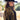 A woman wearing a black wool cowboy hat and a black fringed cape with ornate gold beaded embroidery, photographed outdoors in a sunlit field with trees and a barn-Rider Wool Cowboy Hat Black - Flea Style