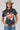 A woman wearing a cotton graphic tee featuring a lived-in charcoal wash, relaxed fit and bold 'She's From Texas Can Tell' graphic design, paired with a beige cowboy hat and jeans-She_s_From_Texas_Graphic_T-Shirt_-_Red-FleaStyle