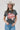 A woman wearing a cotton graphic tee featuring a lived-in charcoal wash, relaxed fit and bold 'She's From Texas Can Tell' graphic design, paired with a beige cowboy hat and jeans-She_s_From_Texas_Graphic_T-Shirt_-_Red-FleaStyle