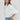 A woman wearing a white puff-sleeve bubble hem , button-up blouse, blue jeans, and a stone cowboy hat-Bubble_Sleeve_Button_Down_Top_-_White-FleaStyle