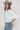A woman wearing a white puff-sleeve bubble hem , button-up blouse, blue jeans, and a stone cowboy hat-Bubble_Sleeve_Button_Down_Top_-_White-FleaStyle