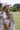 Woman wearing a Camo Ruffle Hem  Shacket with a peace symbol, plaid skirt, and cowboy boots-Fleastyle