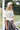 Woman in a Texas-Y_all-GraphicT--Shirt-Ivory  striped skirt standing next to a soccer goal-Fleastyle