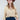 A woman wearing a tan button-up blouse with pearl embellished details, a maroon cowboy hat, and a dark blue denim midi skirt, photographed against a light gray studio background-Pearl_Embellished_Button_Down_Blouse_-_Tan-FleaStyle