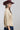A woman wearing a tan button-up blouse with pearl embellished details, a maroon cowboy hat, and a dark blue denim midi skirt, photographed against a light gray studio background-Pearl_Embellished_Button_Down_Blouse_-_Tan-FleaStyle