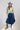 A woman modeling a sage green graphic t-shirt that reads 'Sweet Heart Rodeo Texas', paired with a dark blue A- line denim midi skirt and brown cowboy boots, wearing a dusty blue cowboy hat ,-Dark Denim A-Line Midi Skirt-FleaStyle