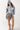 Woman wearing a striped shirt, cowboy boots, and a cap with Striped Elastic Waist Shorts - Green/Pink-Fleastyle