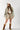 Woman wearing a Camo Ruffle Hem  Shacket with a peace symbol, plaid skirt, and cowboy boots-Fleastyle