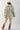 Woman wearing a Camo Ruffle Hem  Shacket with a peace symbol, plaid skirt, and cowboy boots-Fleastyle