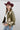 A woman wearing a maroon cowboy hat, olive green western-style jacket with cream and turquoise accents, a white ribbed crop top, blue jeans, and a pair of oval silver-toned concho-style earrings-earrings with turquoise-colored inlay stones Western_Inspired_Scalloped_Earrings-FleaStyle.