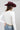 A woman wearing a classic long-sleeve tee features a flattering, fitted silhouette with an elegant boat neckline worn alone or styled as an effortless layering piece--Boat_Neck_Long_Sleeve_Top_-_Ivory-FleaStyle